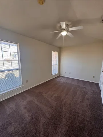 an empty room with windows and fan