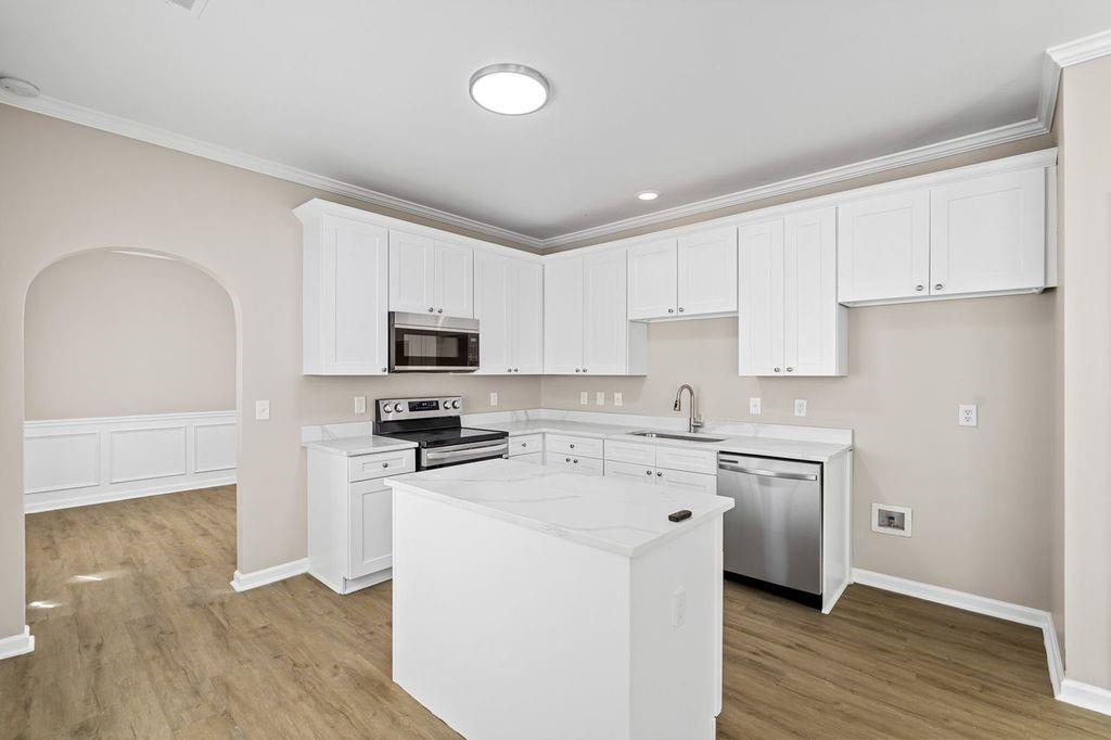 473 Greyhawk Way Fairburn, GA 30213 - Photo 8 of 34 a kitchen with stainless steel appliances granite countertop a stove top oven a sink and white cabinets with wooden floor