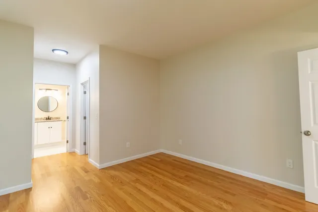 a view of empty room with wooden floor