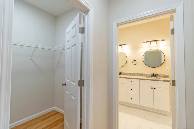 a bathroom with a granite countertop sink vanity mirror and glass door