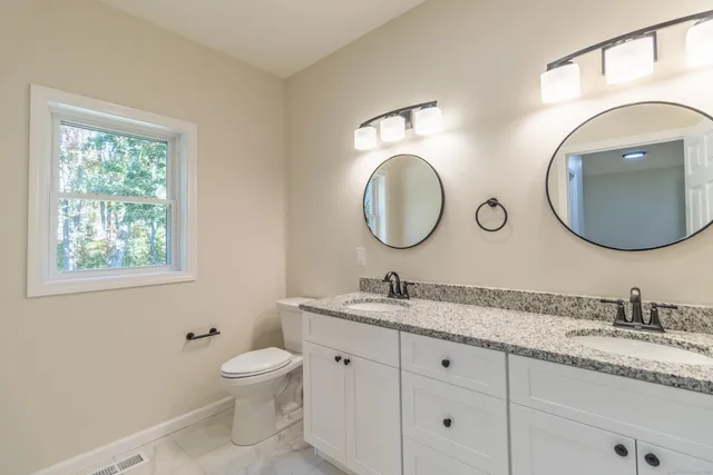 a bathroom with 2 sink and a mirror