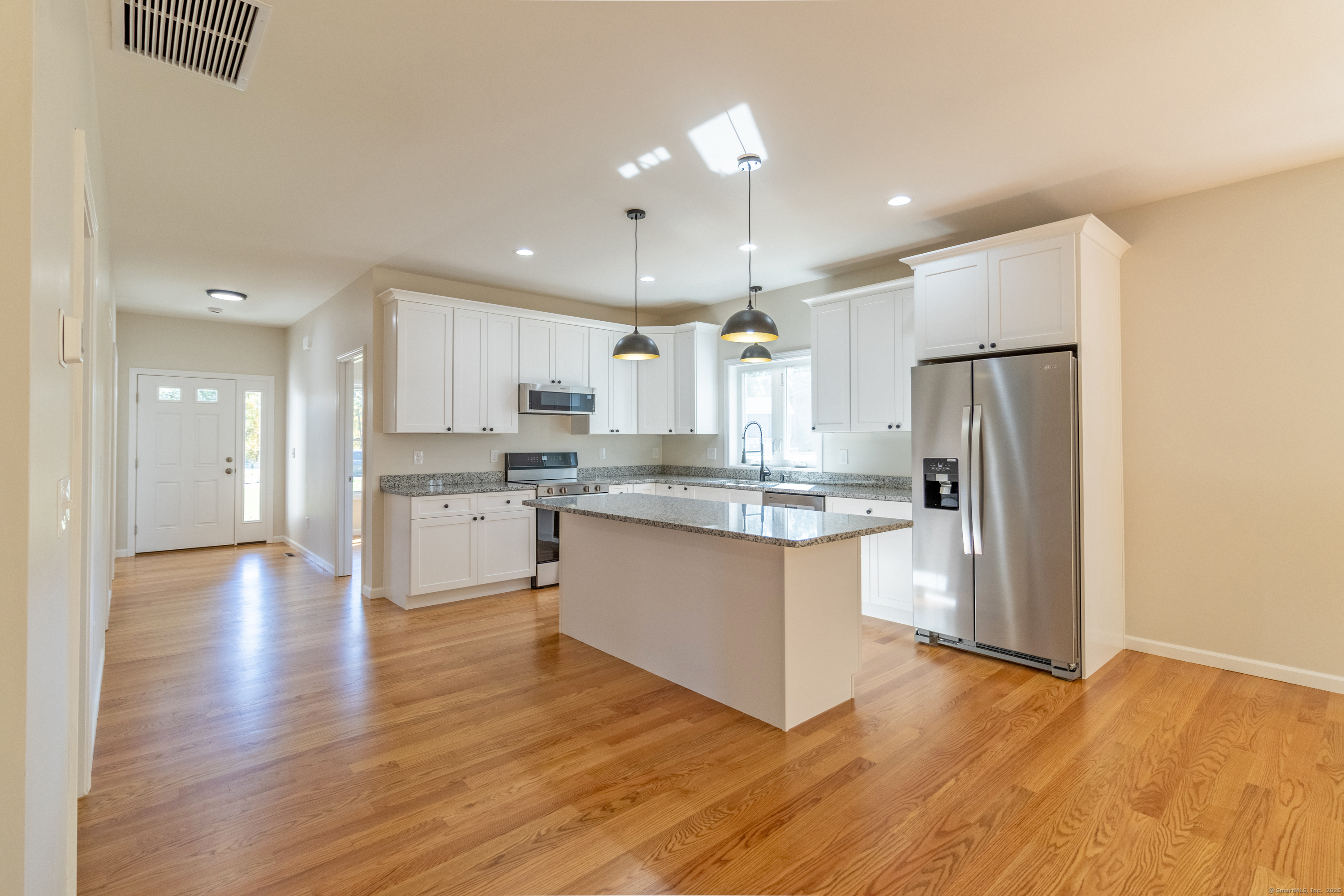 18 Spring Hill Road Storrs Mansfield, CT 06268 - Photo 10 of 31 a kitchen with stainless steel appliances granite countertop a refrigerator a sink dishwasher a stove and white cabinets with wooden floor