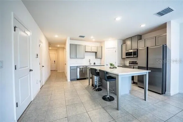 a kitchen with kitchen island granite countertop a sink counter top space appliances and cabinets