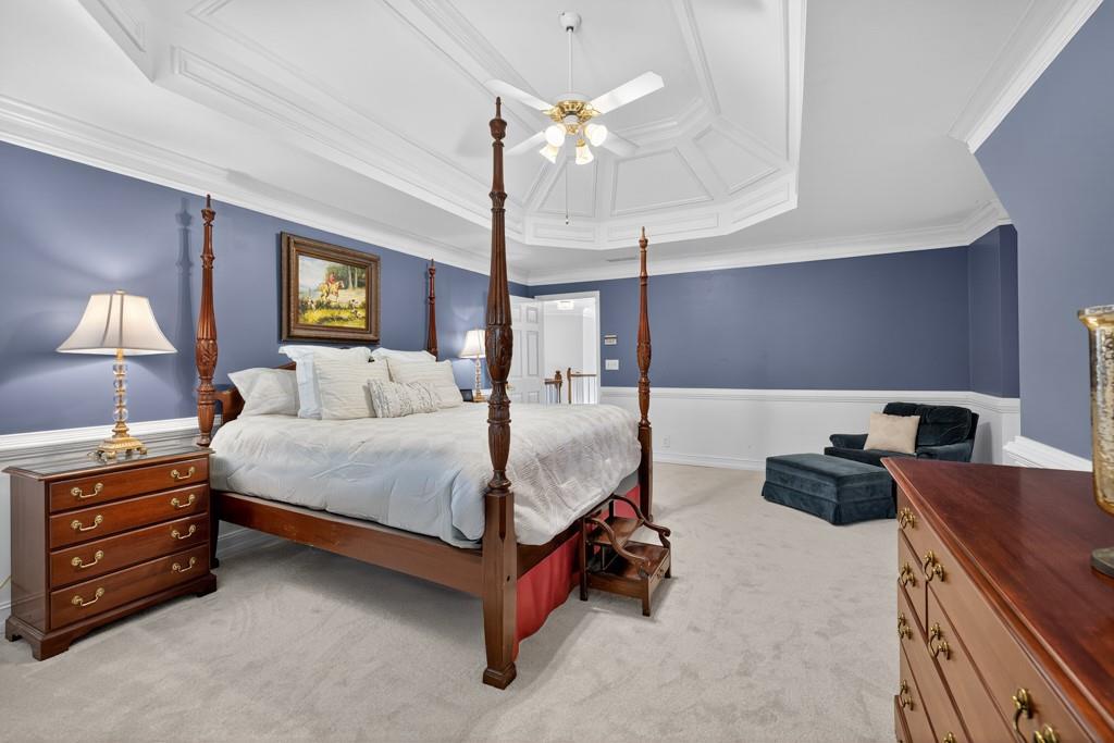 1430 Roanoke Trace Grayson, GA 30017 - Photo 24 of 62 a bedroom with bed a chandelier and a flat tv screen on dresser