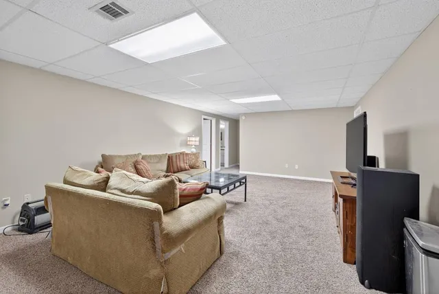 a view of a house with a big yard and large trees