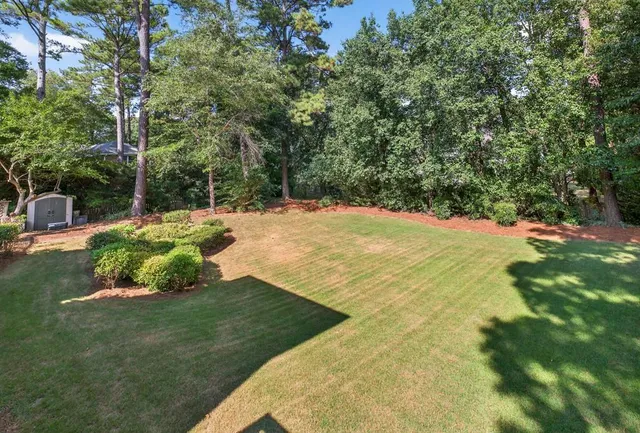 an aerial view of a house with swimming pool and wooden fence