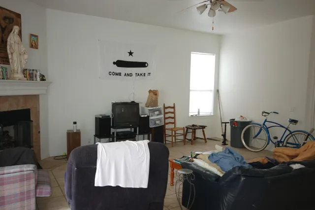 a bedroom with furniture a flat screen tv and a window