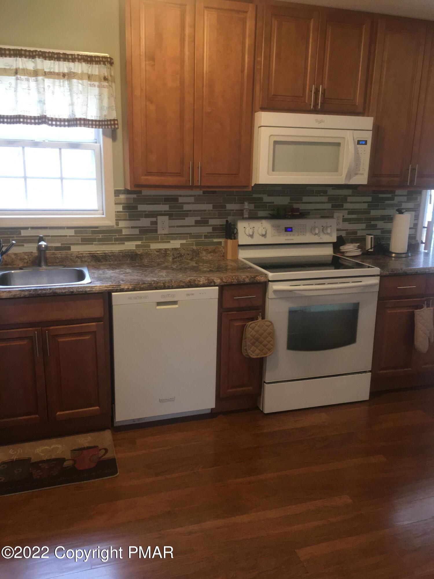 177 Granite Road Long Pond, PA 18334 - Photo 6 of 16 a kitchen with stainless steel appliances granite countertop a stove a microwave and a sink
