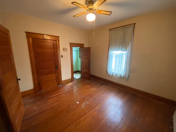 wooden floor in an empty room with a window