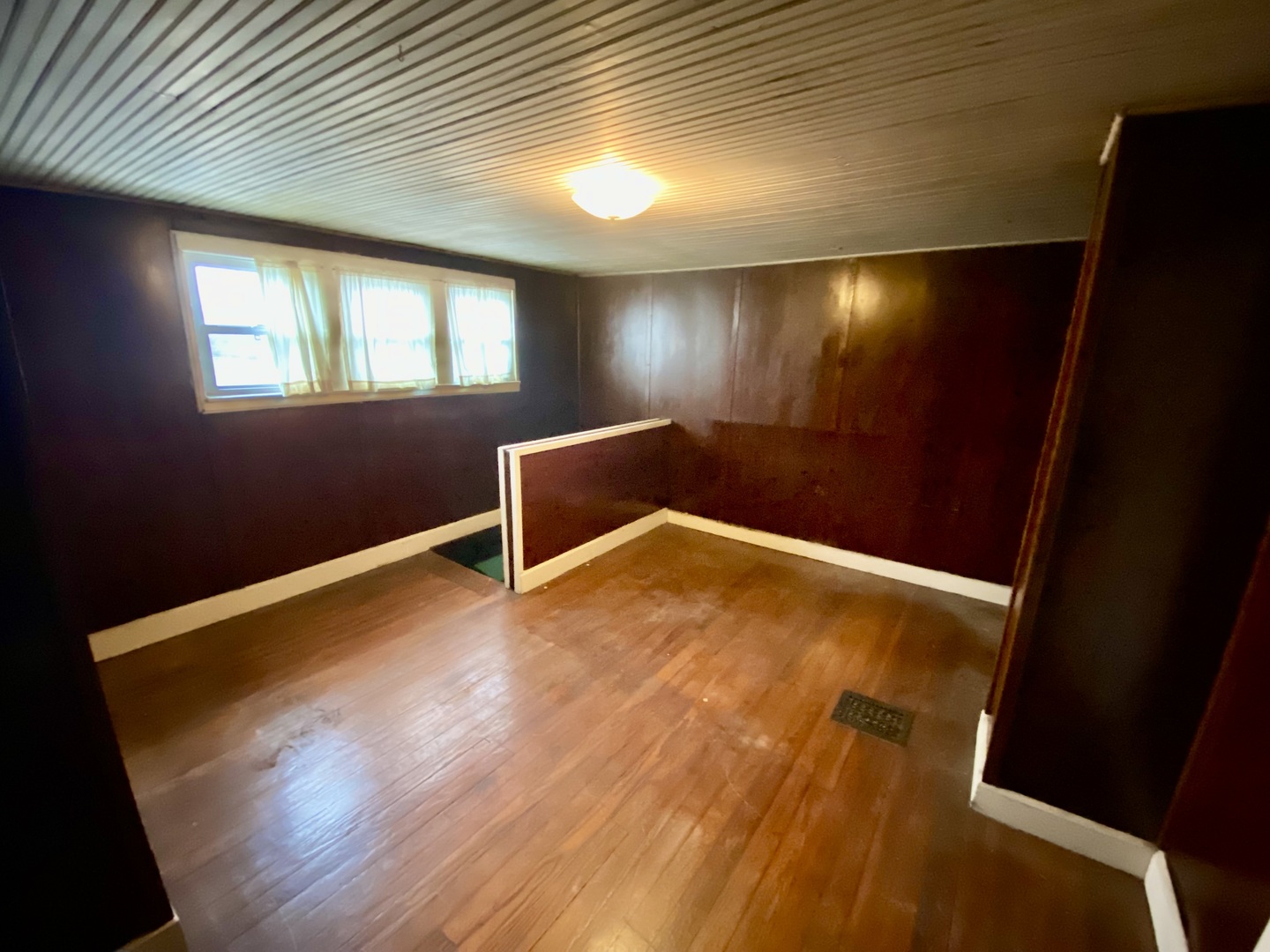 210 Rolston Street Centralia, IL 62801 - Photo 6 of 9 a view of an empty room with wooden floor and a window
