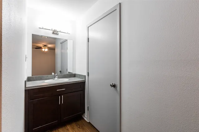 a bathroom with a granite countertop sink a toilet and mirror