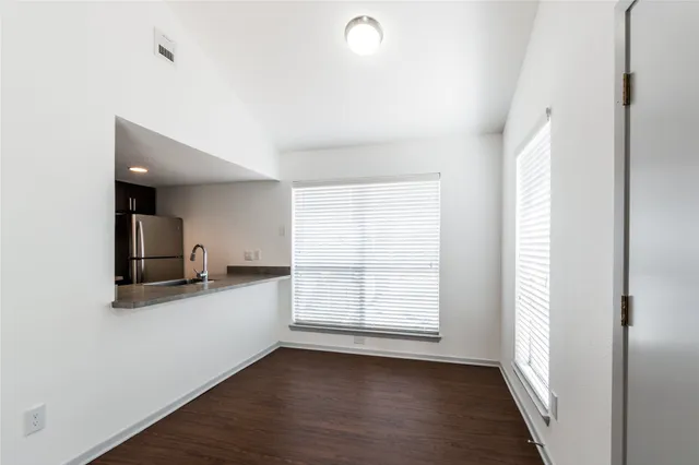 a view of a kitchen with wooden floor and a window