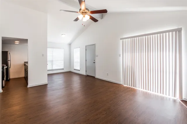 a view of a livingroom with wooden floor and a ceiling fan