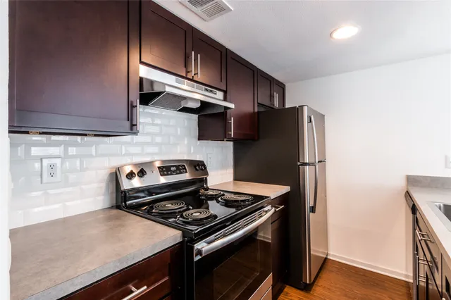 a kitchen with stainless steel appliances granite countertop a refrigerator and a stove