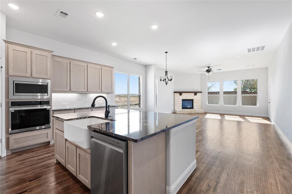 613 Brazos Drive Van Alstyne, TX 75495 - Photo 1 of 29 Kitchen with dark stone counters, healthy amount of natural light, appliances with stainless steel finishes, a kitchen island with sink, and recessed lighting