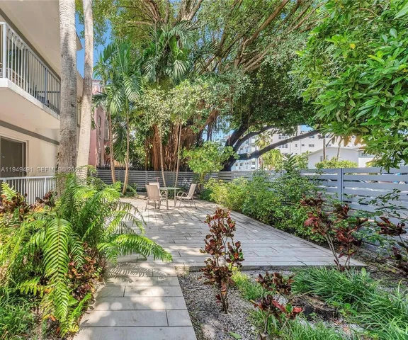 a view of backyard with table and chairs and potted plants