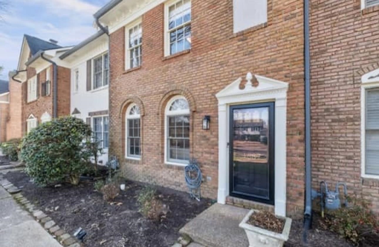 a view of a brick house with many windows