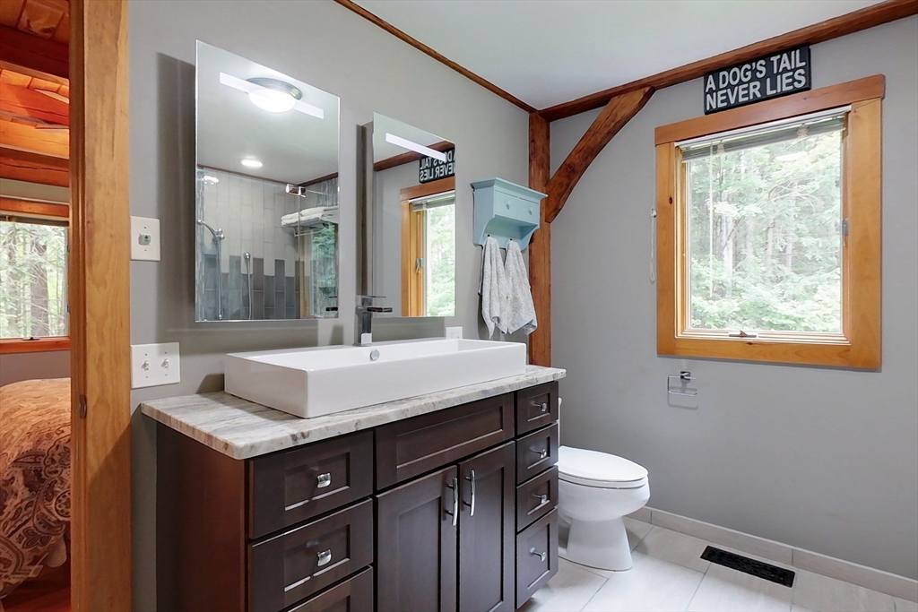 23 A Heald Street Pepperell, MA 01463 - Photo 19 of 42 a bathroom with a granite countertop sink toilet and mirror