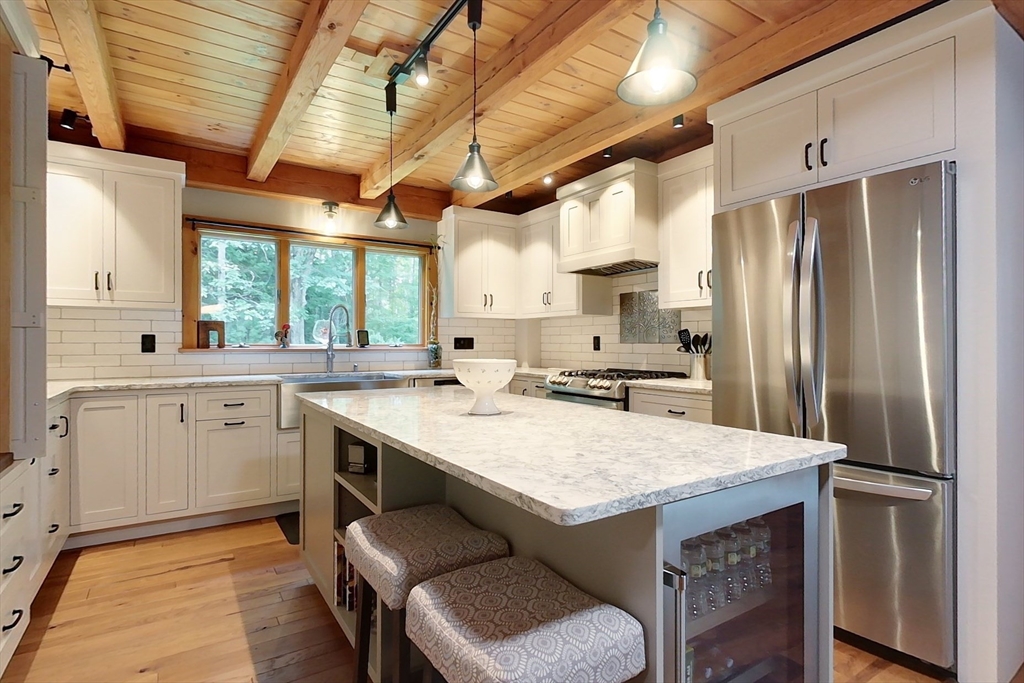 23 A Heald Street Pepperell, MA 01463 - Photo 7 of 42 a kitchen with a table chairs refrigerator and a sink