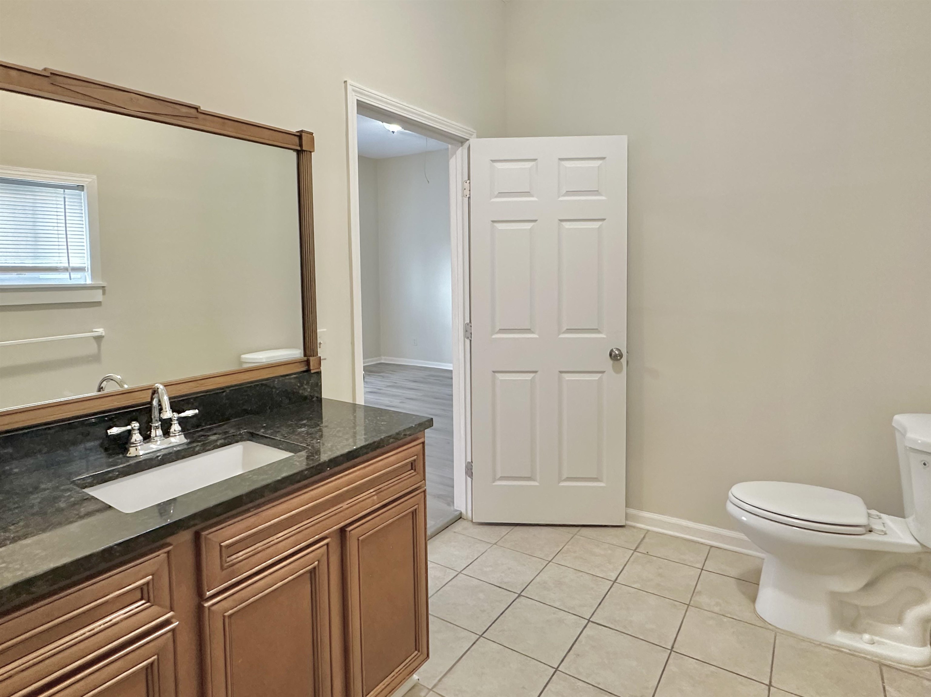 2195 Carnes Avenue Memphis, TN 38114 - Photo 26 of 30 a spacious bathroom with a granite countertop sink a toilet a mirror and a shower