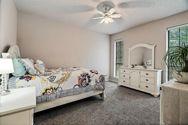 a bedroom with a bed a chandelier and dresser