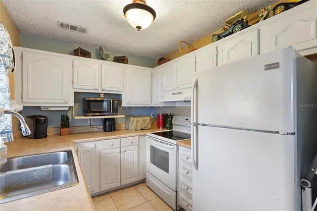 a kitchen with white cabinets and white appliances