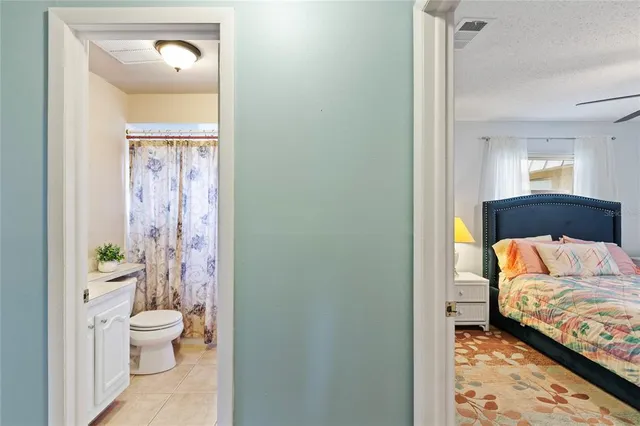 a en suite bathroom with a granite countertop sink and a toilet