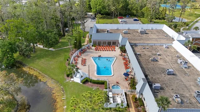 an aerial view of a house with a garden and lake view