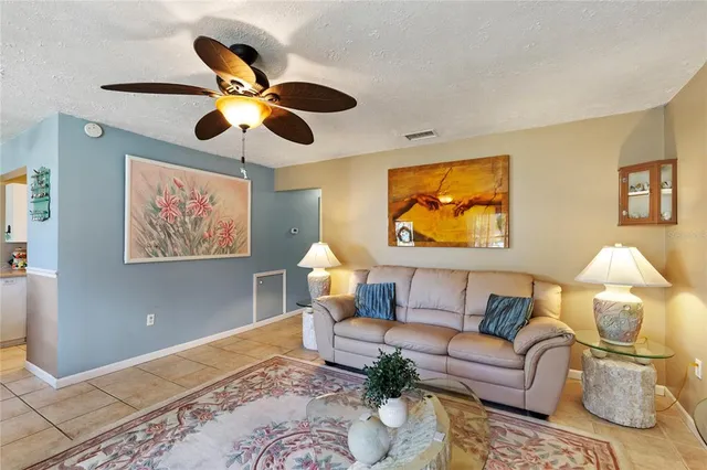 a living room with furniture and a ceiling fan