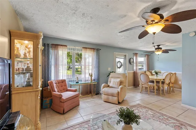 a living room with furniture ceiling fan and a window