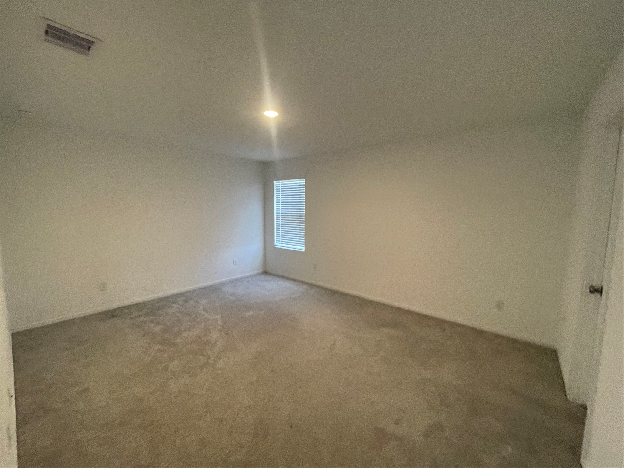 112 Stran Street Wharton, TX 77488 - Photo 13 of 23 Positioned for ultimate seclusion, the primary suite is a sprawling, carpeted room bathed in natural light.