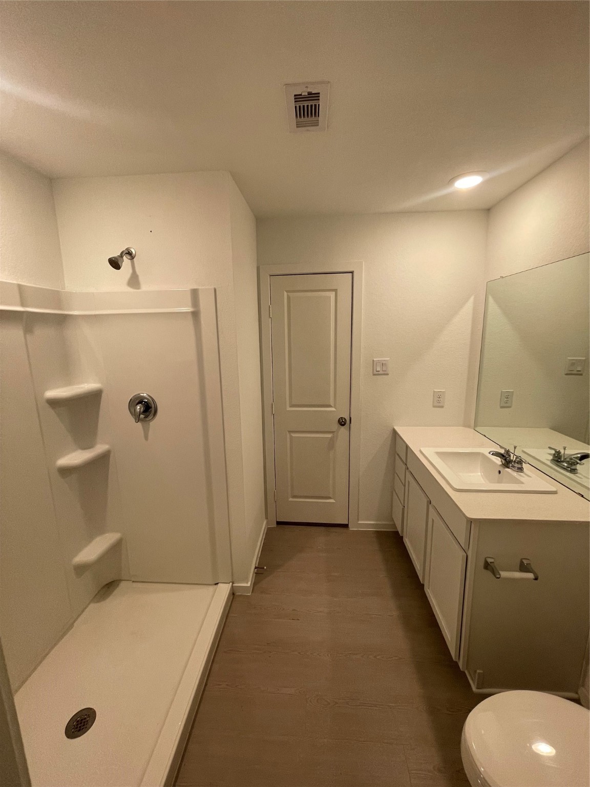 112 Stran Street Wharton, TX 77488 - Photo 15 of 23 The private bathroom features a wide vanity and a spacious shower, reflecting a clean and contemporary aesthetic.