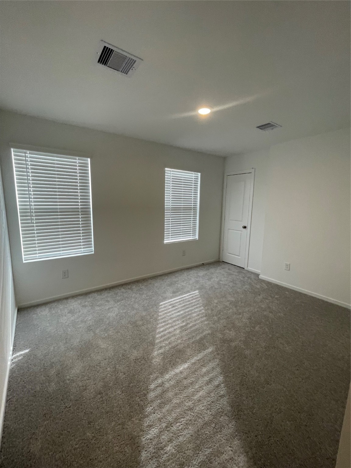 112 Stran Street Wharton, TX 77488 - Photo 21 of 23 Tall windows elevate the cozy atmosphere of this final bedroom, offering a bright vantage point over the surrounding neighborhood.