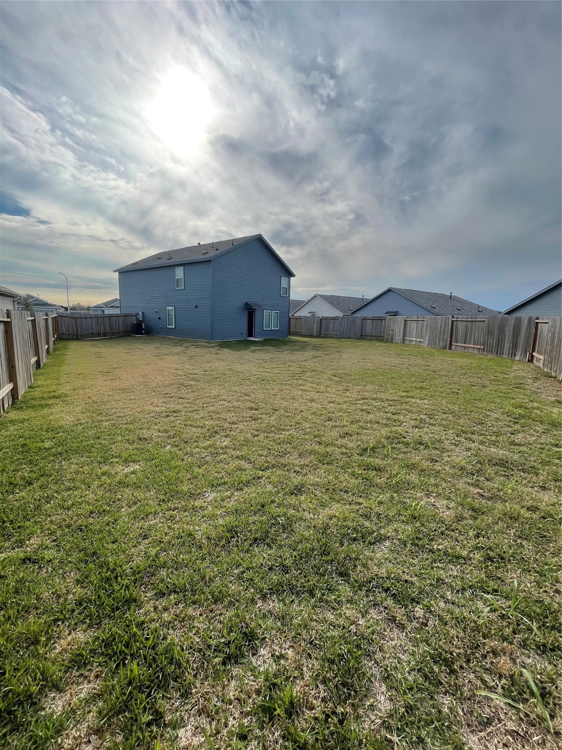 112 Stran Street Wharton, TX 77488 - Photo 22 of 23 The backyard reveals a massive, verdant stretch of fully fenced lawn, providing a vast private canvas for outdoor recreation and weekend gatherings.