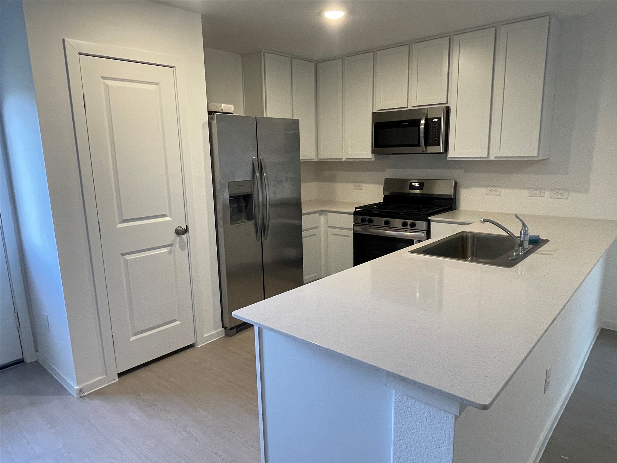 112 Stran Street Wharton, TX 77488 - Photo 4 of 23 The kitchen features a substantial peninsula island that serves as both a prep station and a social anchor, complete with a roomy pantry and sleek cabinetry.