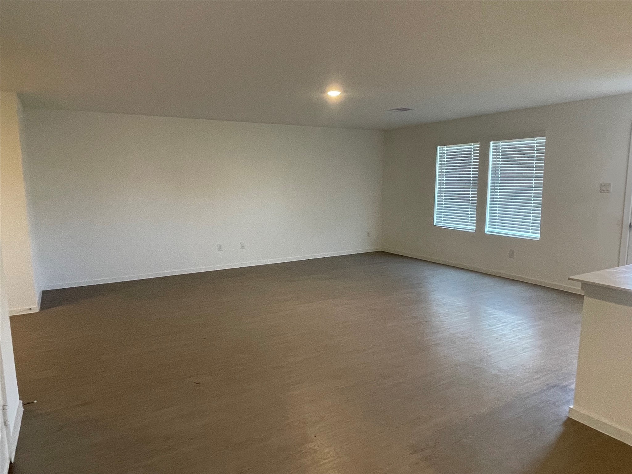 112 Stran Street Wharton, TX 77488 - Photo 9 of 23 The living area is defined by its generous footprint and tall windows, creating a light-filled, airy environment for relaxation.