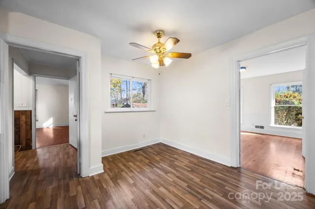a view of empty room with wooden floor
