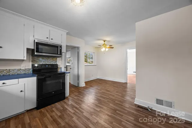 a kitchen with granite countertop a refrigerator and a stove top oven