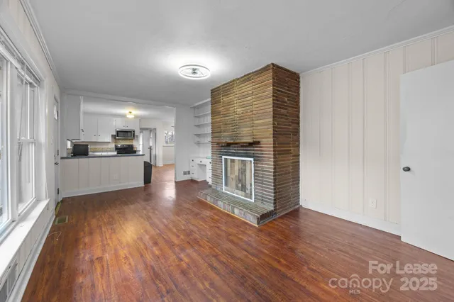a view of a kitchen with wooden floor and a refrigerator