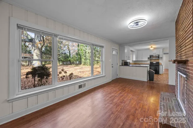 a view of a kitchen with wooden floor electronic appliances and furniture