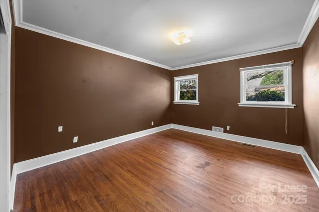 a view of empty room with wooden floor
