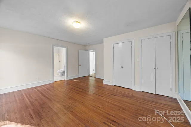 a view of empty room with wooden floor and entryway