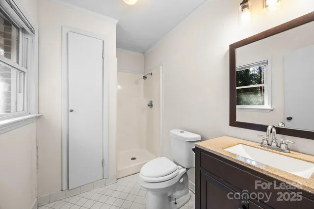 a bathroom with a granite countertop sink a toilet and a mirror