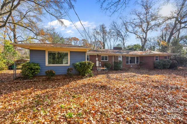 a front view of house with yard and trees around