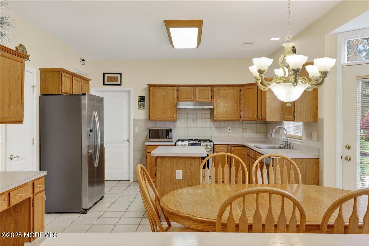 508 Lanzaro Drive Morganville, NJ 07751 - Photo 17 of 48 a kitchen with stainless steel appliances granite countertop a sink dishwasher a refrigerator with a dining table and chairs