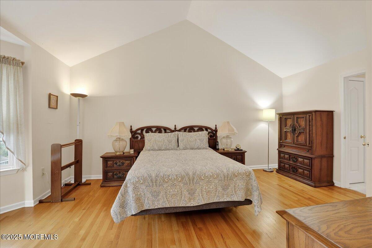 508 Lanzaro Drive Morganville, NJ 07751 - Photo 26 of 48 a bedroom with a bed and dresser with wooden floor