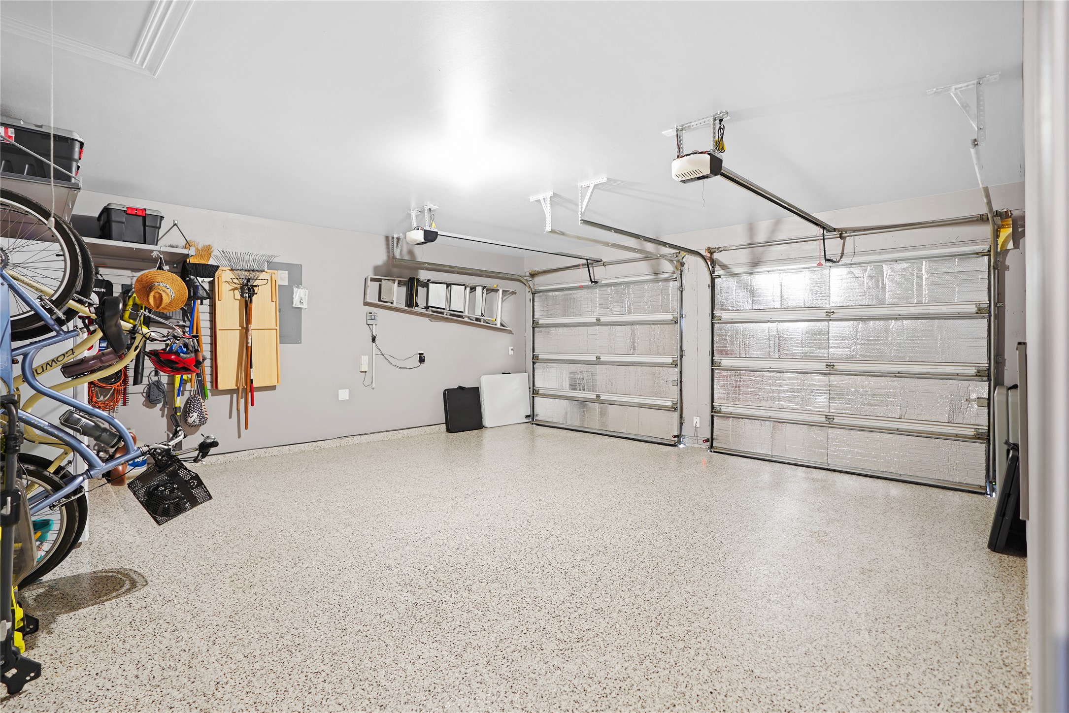 2345 Redwood Ridge Trail Manvel, TX 77578 - Photo 35 of 39 Spacious and well-organized two-car garage with polished floors, overhead storage, and wall-mounted racks for tools and bicycles. Perfect for parking and additional storage.