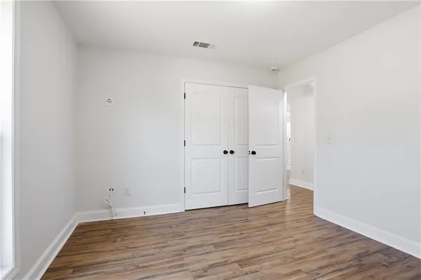 a view of an empty room with wooden floor