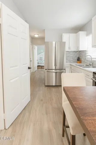 a kitchen with a refrigerator a sink and cabinets