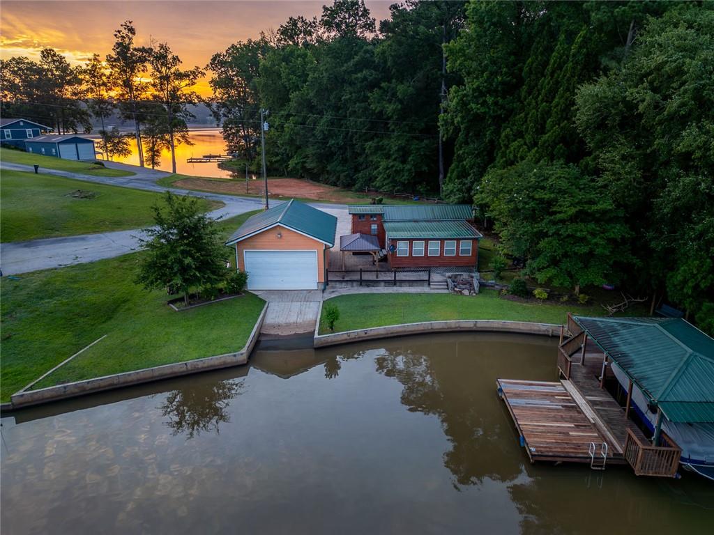 an aerial view of a house with a garden and lake view